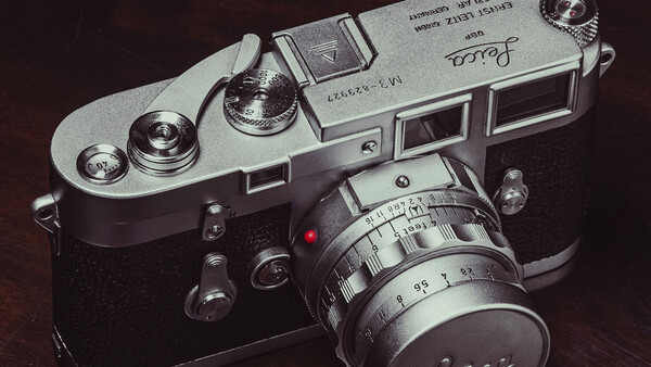 Vintage rangefinder camera with chrome top plate and black body, fitted with a manual focus lens.