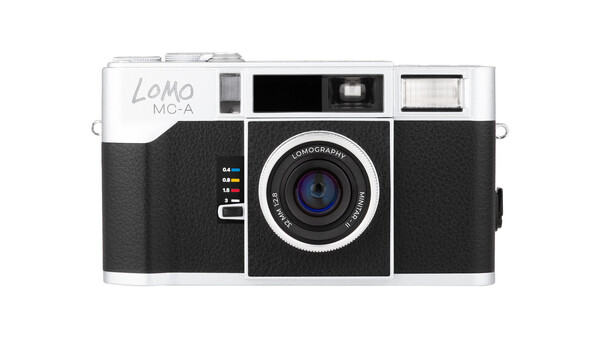 Lomo LC-A film camera with white top plate, black leatherette body, and Lomography lens against white background.