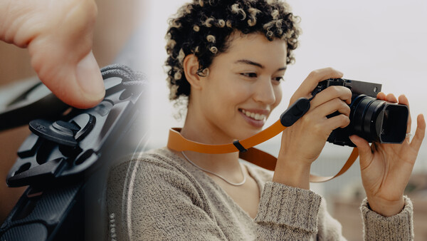 Smiling person holding a compact digital camera with an orange shoulder strap, with a detail shot of camera controls on the left.