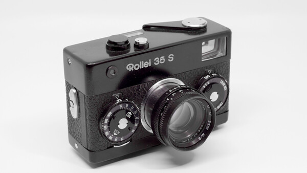 Rollei 35 S compact film camera with black body and textured grip, showing dual manual control dials and fixed lens.