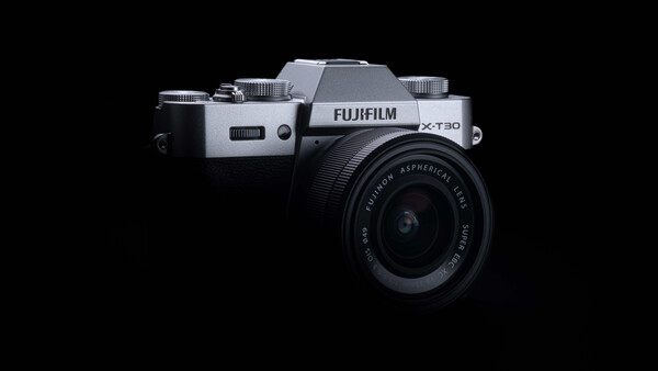 Fujifilm X-T30 mirrorless camera with kit lens against black background.