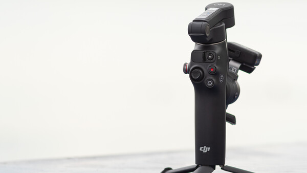 DJI gimbal stabilizer mounted on stand against white background.