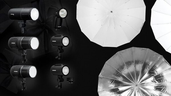 Professional studio lighting setup with multiple LED panel lights and large diffusion umbrellas arranged on black background.
