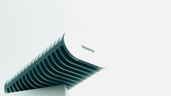 Curved architectural structure with parallel ridged lines against a light background.