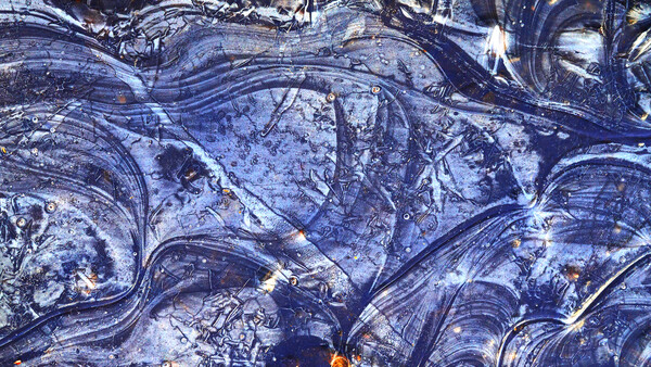 Aerial view of winding roads and water features with blue and gold tones.
