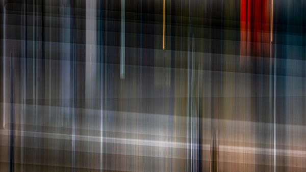 Abstract vertical light streaks and blurred architectural elements with warm and cool color tones.