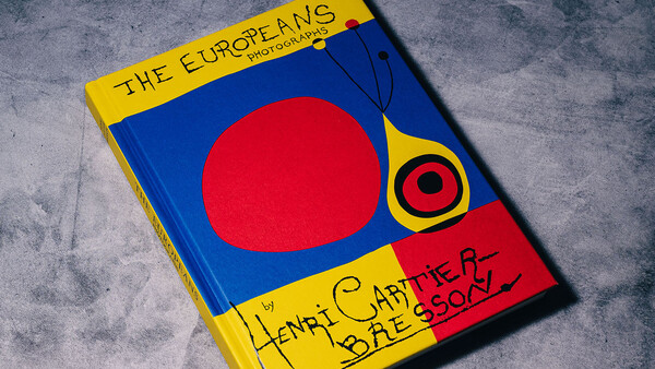 Book cover with bold primary colors featuring a large red circle on blue background and yellow border with handwritten text.