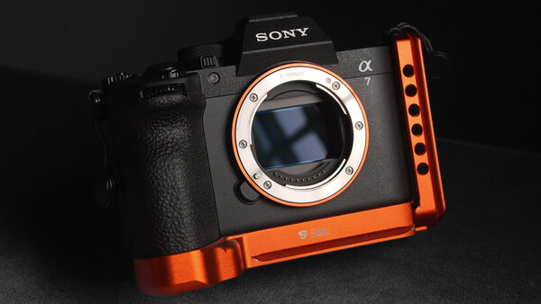 Sony α7 mirrorless camera with orange L-bracket accessory mounted on bottom.