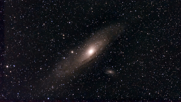 Spiral galaxy with bright central core surrounded by dust lanes and stars against dark space.