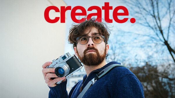 Photographer holding a rangefinder camera with a red 'create.' text overlay above.