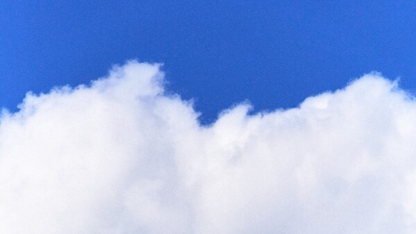 Puffy white cumulus clouds against a vibrant blue sky
