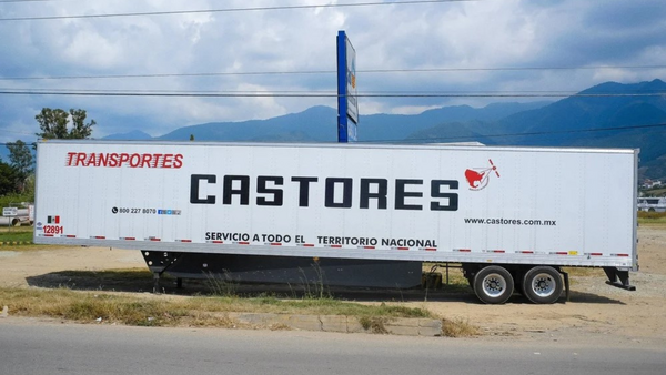 White commercial transport truck with 'Castores' branding parked against mountain landscape