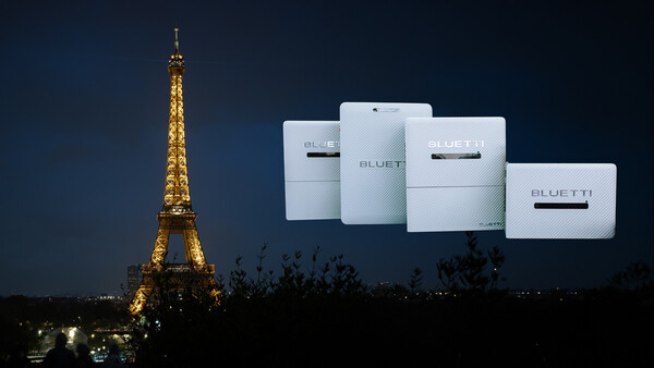Eiffel Tower illuminated at night with white Bluetti portable power stations displayed overhead