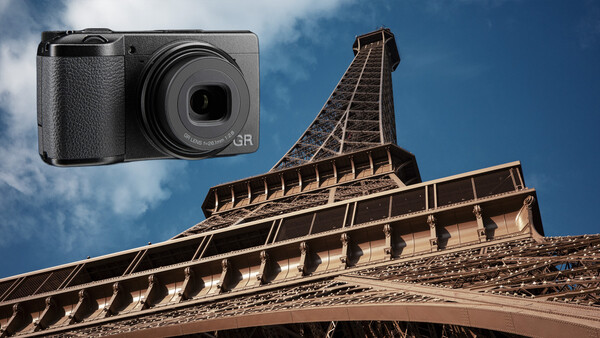 Ricoh GR compact camera overlaid on architectural photograph of Eiffel Tower