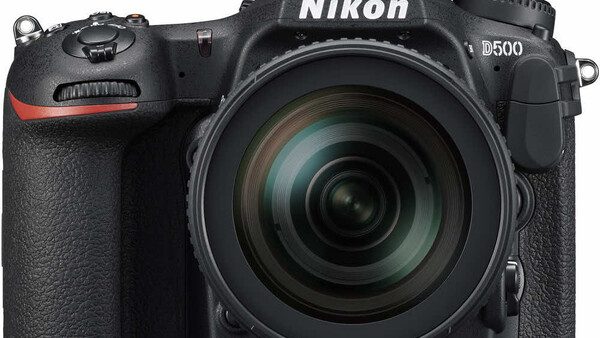 Nikon D500 DSLR camera with 18-140mm kit lens on white background