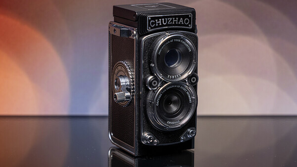 Chuzhao twin-lens reflex camera with dark leather covering displayed against warm and cool gradient lighting