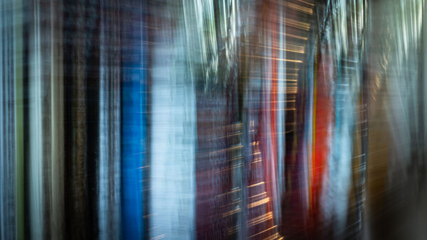 Vertical motion blur of tall buildings with red, blue, and warm-toned glass facades