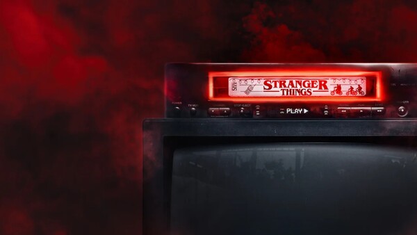 Neon sign reading 'Stranger Things' glowing red above a dark media player or display screen