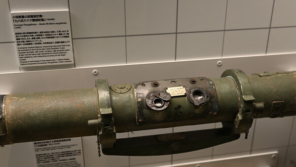 Military rocket launcher or missile system with olive drab cylindrical tubes mounted on display