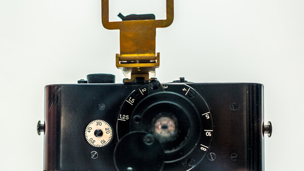 Vintage film camera with wide-angle lens and pop-up viewfinder, top-down view against white background