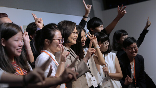 Group of women raising their hands and cheering together at an indoor event
