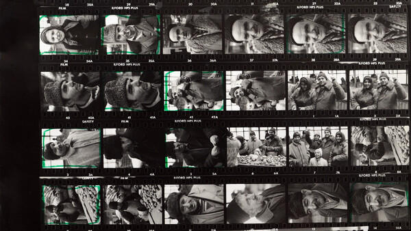 Contact sheet of black and white film negatives with cyan selection marks indicating chosen frames