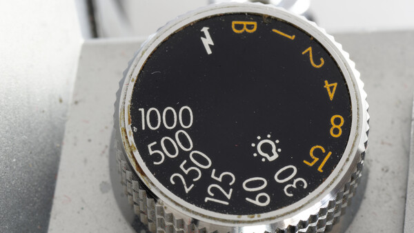 Close-up of camera aperture dial with f-stop numbers and shutter speed markings