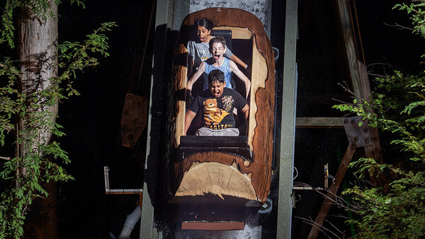 Overhead shot of four people on an amusement park ride captured from directly above