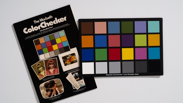The Macbeth ColorChecker color reference chart with instruction booklet on neutral background