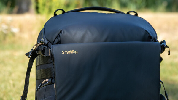 SmallRig backpack with padded compartment displayed outdoors against blurred green background