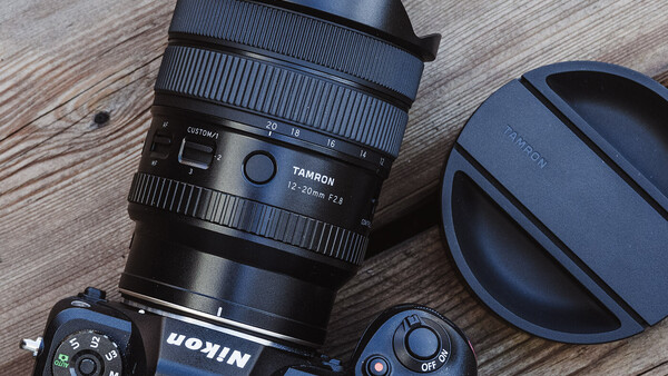 Tamron lens with lens cap and camera body on wooden surface