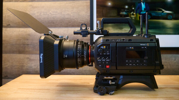 Blackmagic cinema camera with SmallRig matte box and 24mm cine lens mounted on a wooden table