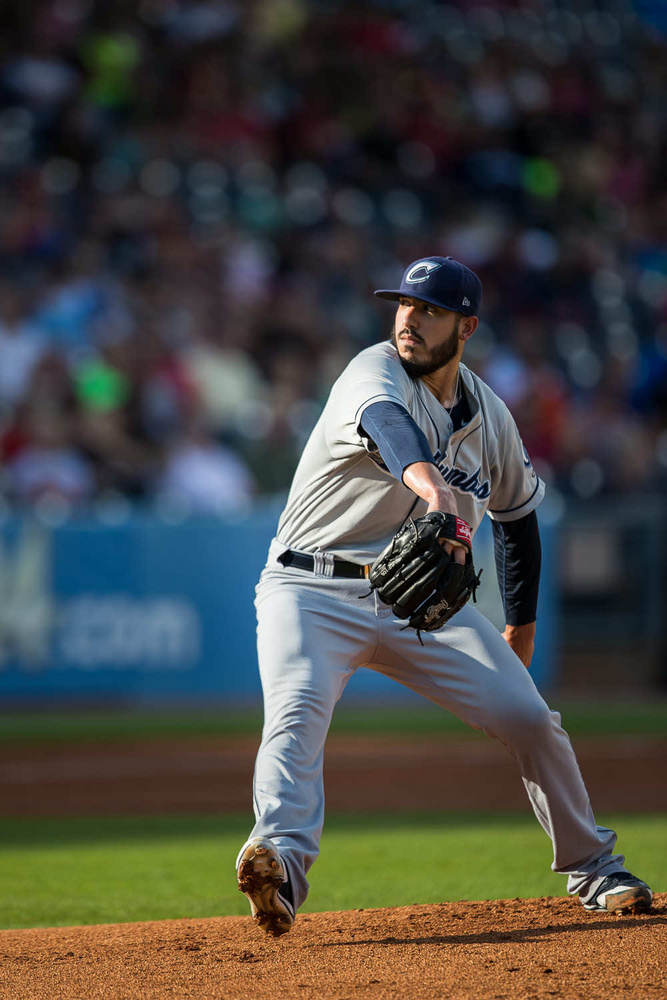 A baseball player mid-swing at a game