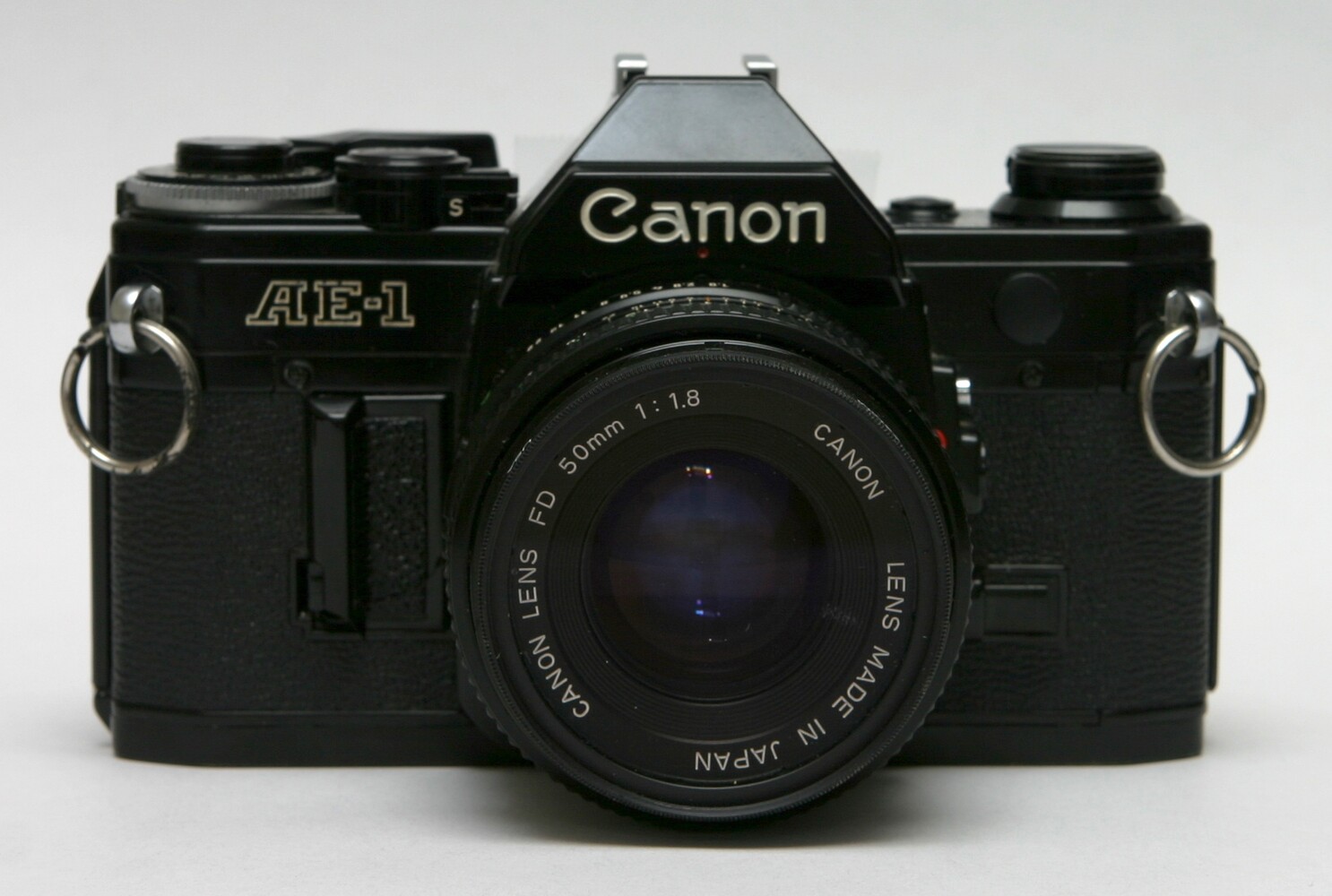 Пленочная камера Canon AE-1 с объективом FD 50mm f/1.8 на белом фоне