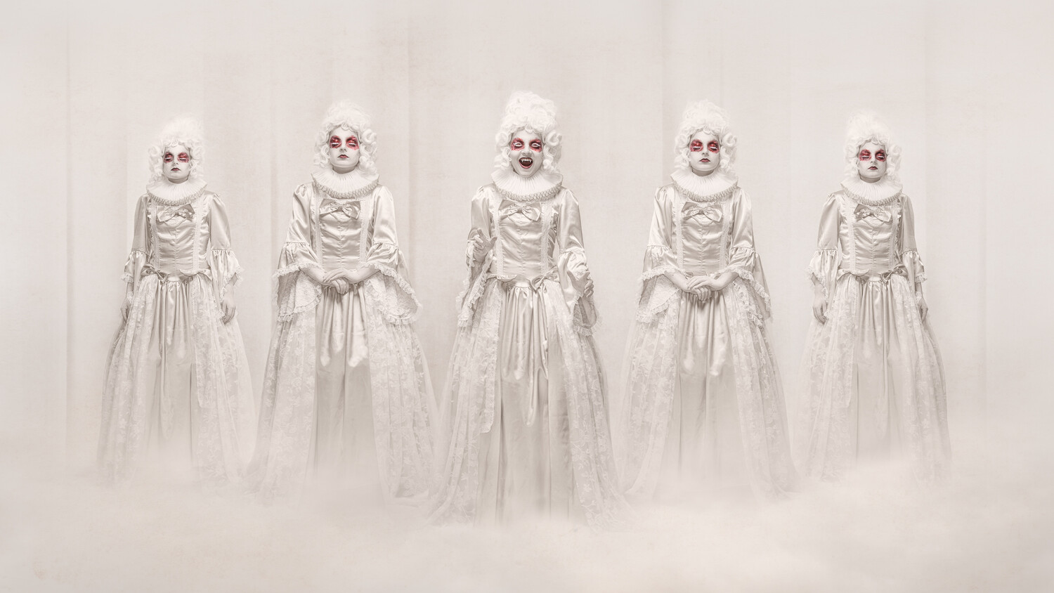 Five figures in white skeletal makeup and ethereal gowns standing in mist