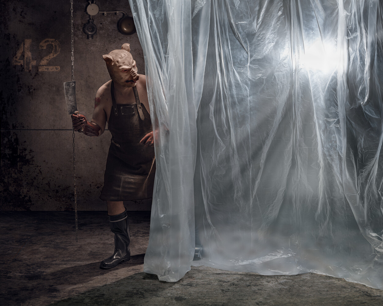 Woman in dark dress standing beside translucent white fabric panels in industrial studio setting