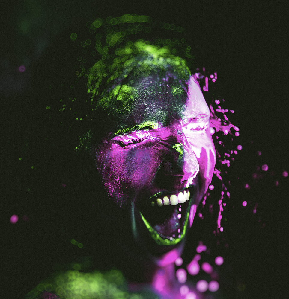 Man's face with explosive paint effect in neon green and magenta