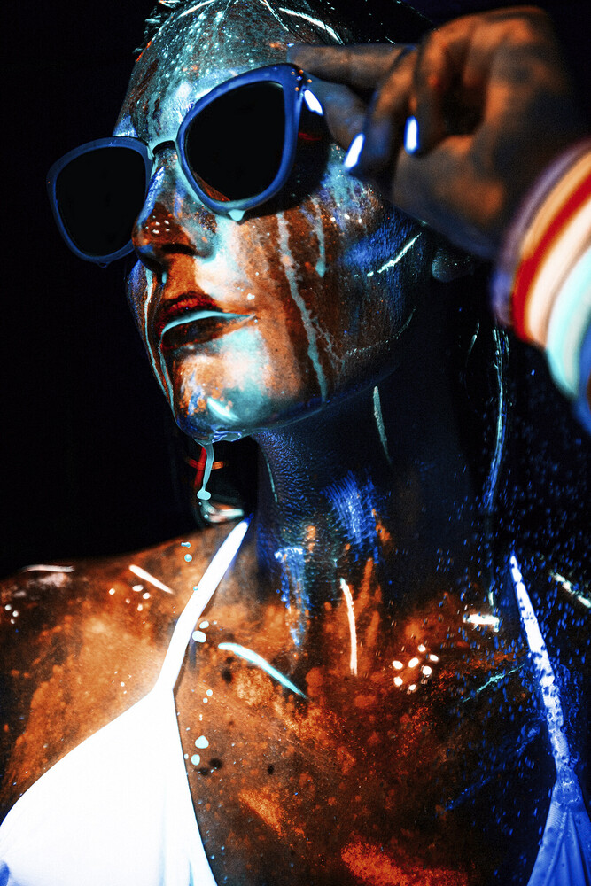Portrait of a person with blue-tinted sunglasses and dramatic blue and orange lighting