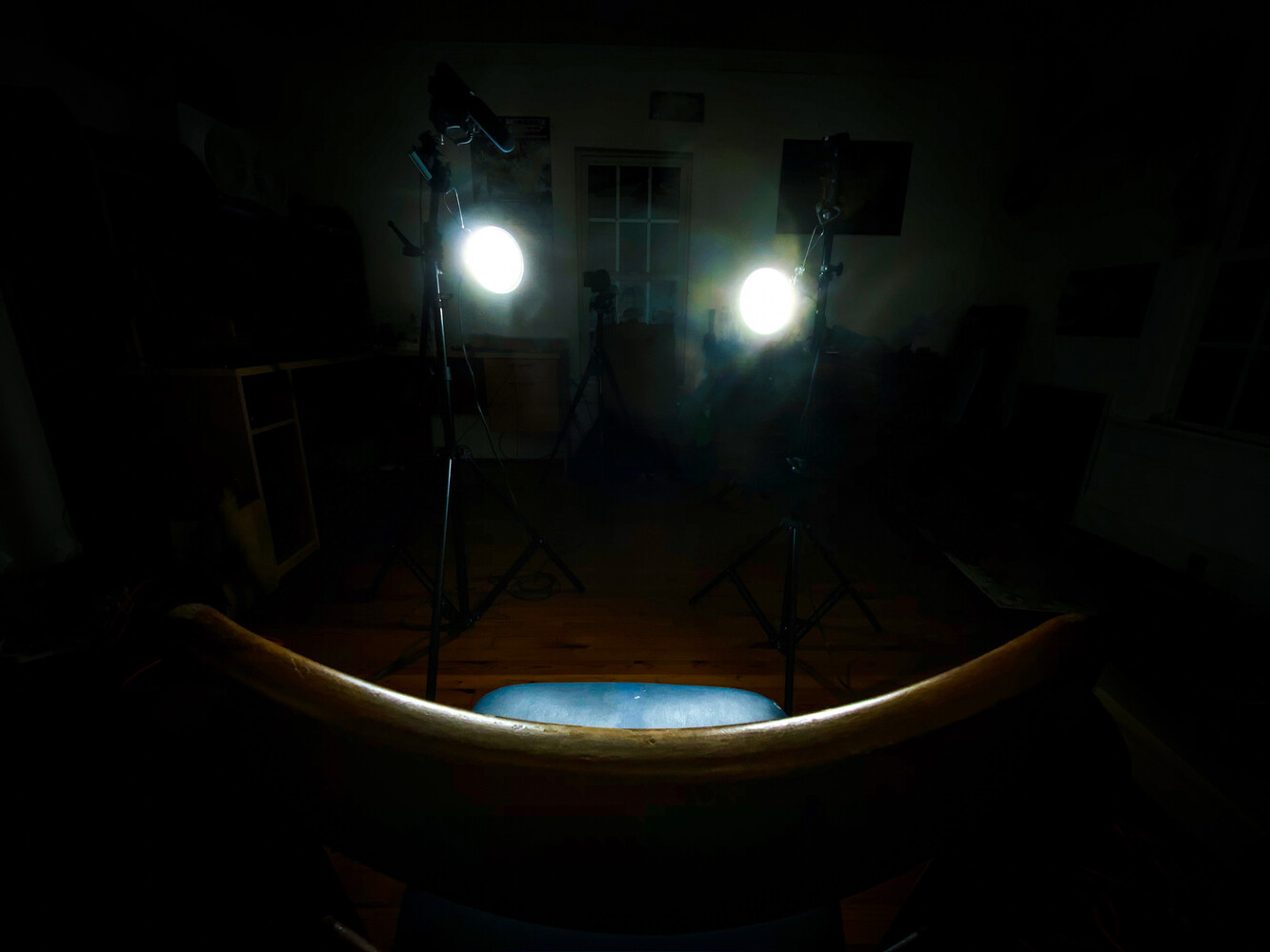 Studio setup with two professional lights illuminating a curved blue surface against a dark background