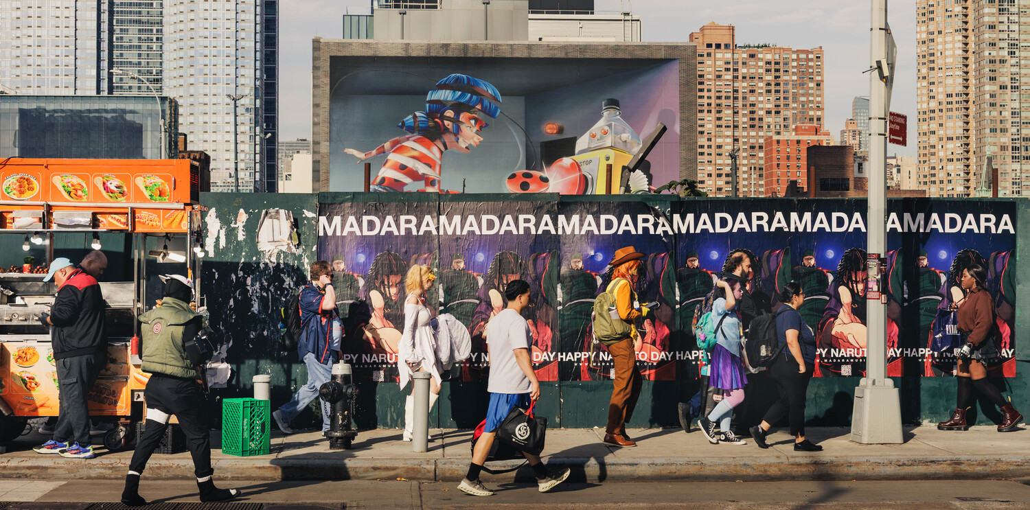 Crowded urban street scene with people queuing at storefront displaying repeated MADARA branding