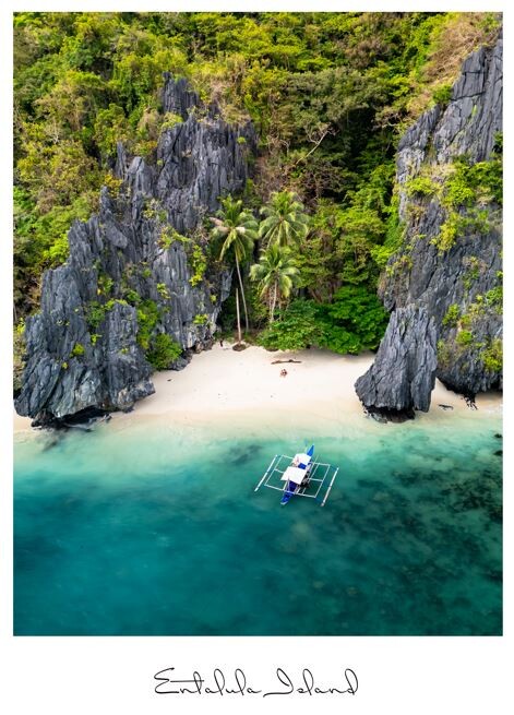 Aerial view of a tropical beach cove with limestone cliffs and turquoise water, moored boat visible
