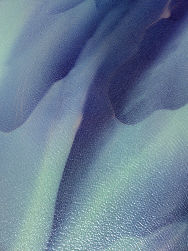 Close-up of folded fabric with soft blue and purple tones showing texture and depth