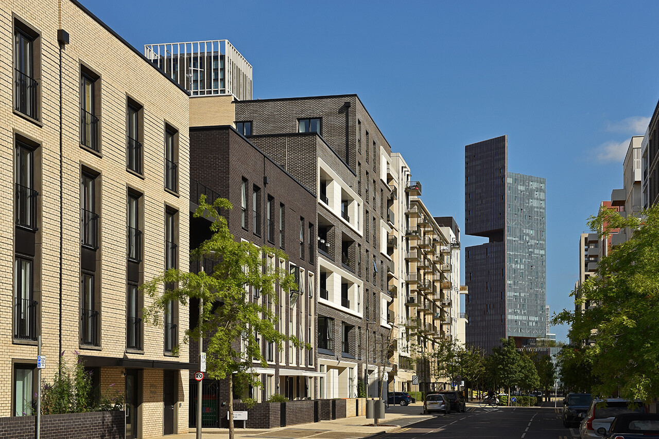 Modern mixed-use urban street with contemporary residential and commercial buildings under clear blue sky