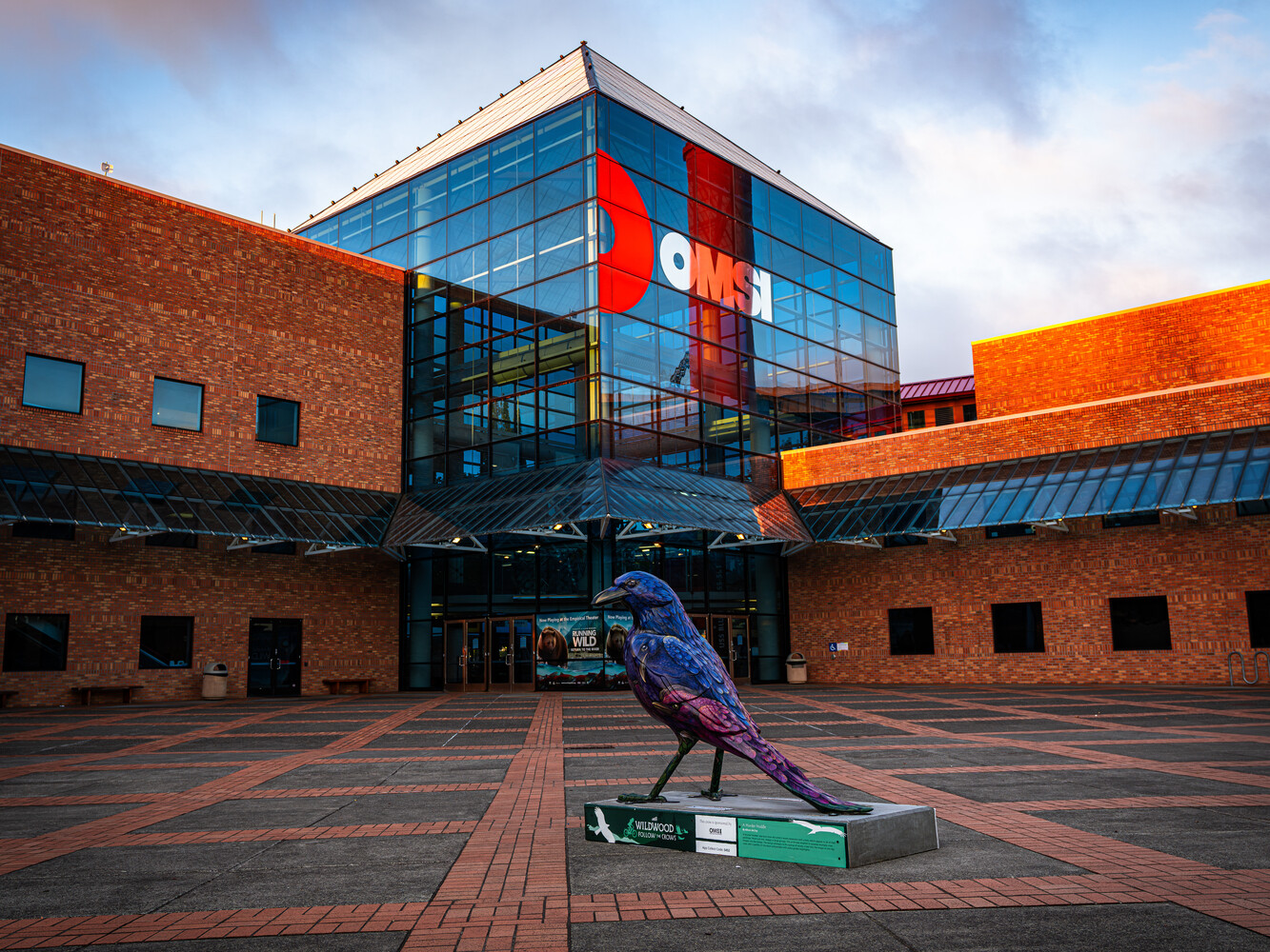 Purple bird sculpture in courtyard of modern brick and glass building complex