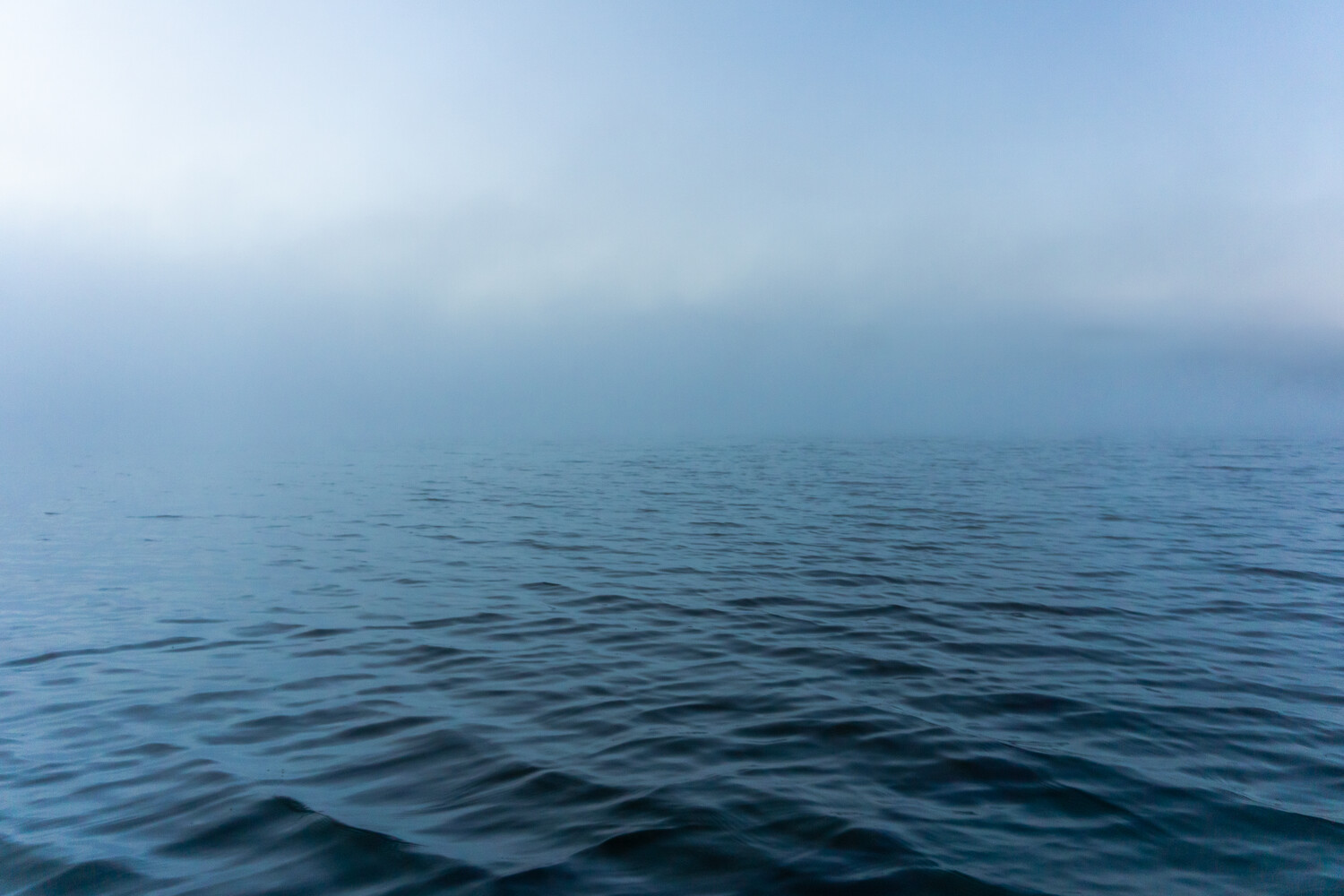 Calm ocean surface with subtle wave patterns under overcast sky