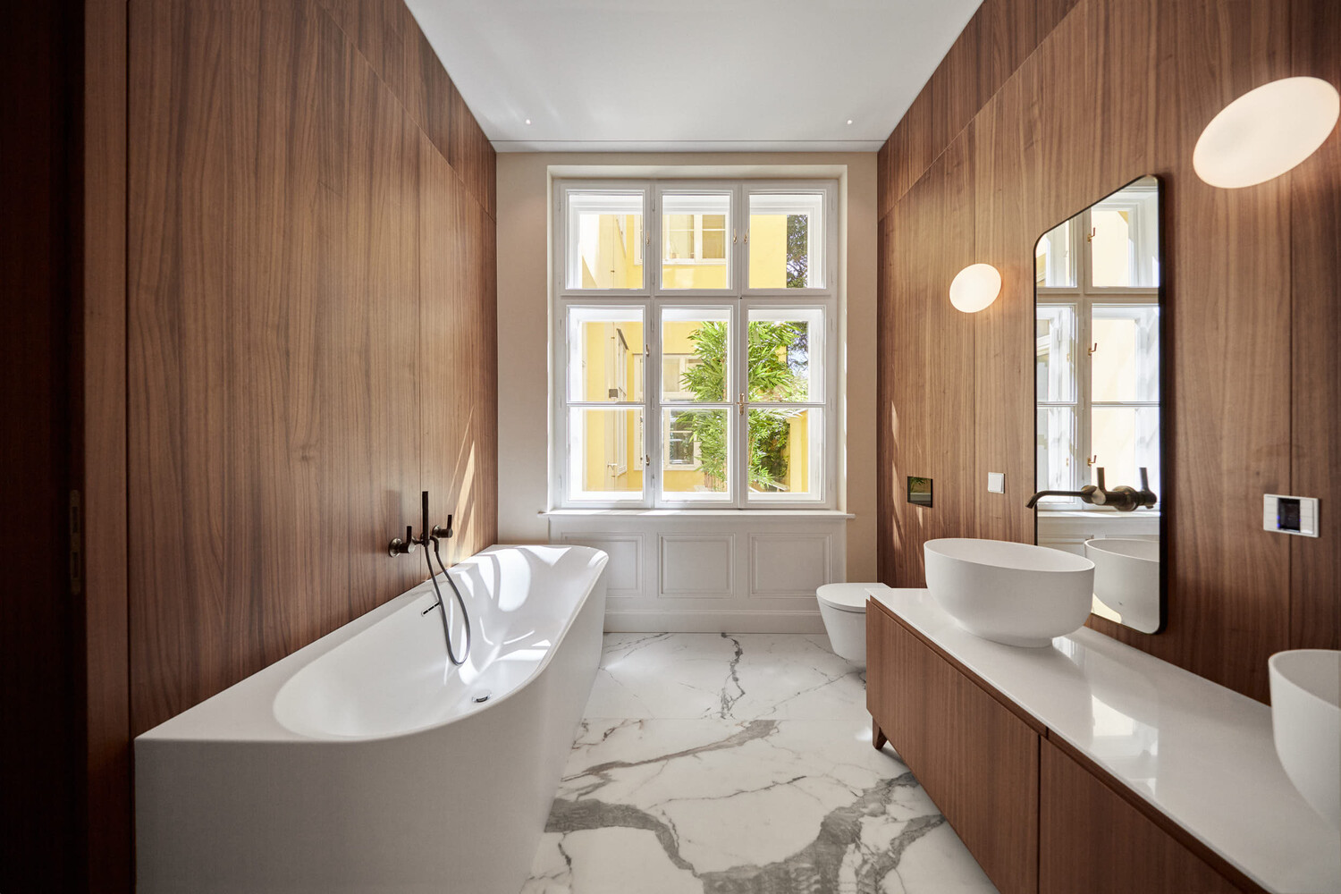 Luxury bathroom interior with wooden wall paneling, white freestanding bathtub, and marble flooring