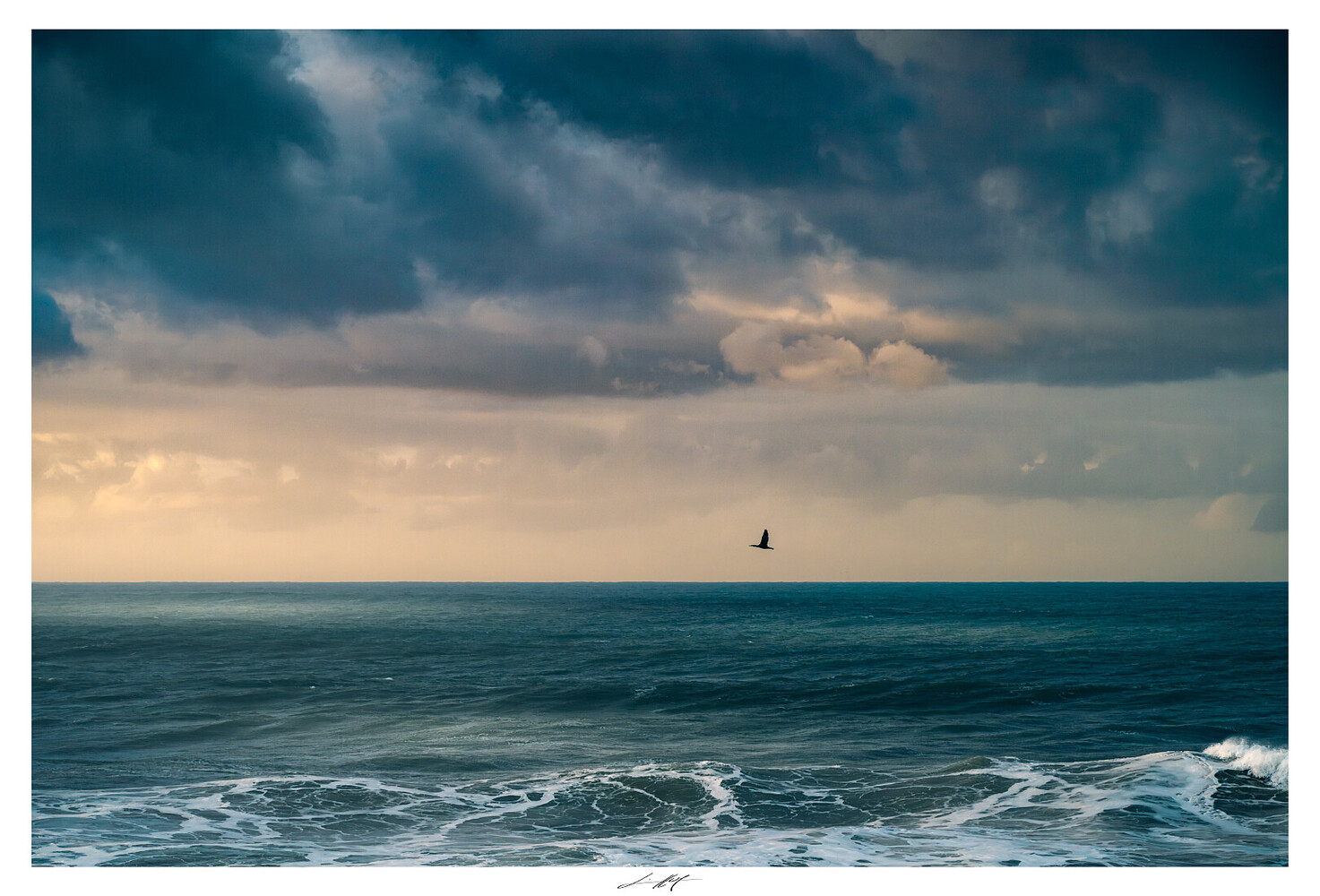 Solitary sailboat on horizon beneath dramatic cloudy sky over calm ocean waves