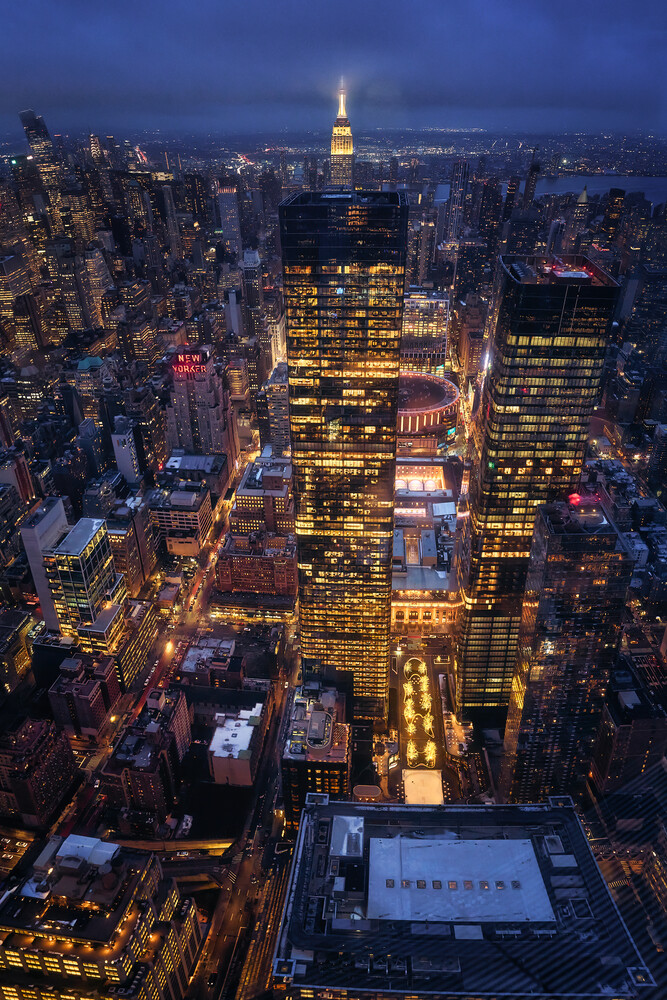 Manhattan skyline at twilight with Empire State Building illuminated among surrounding skyscrapers