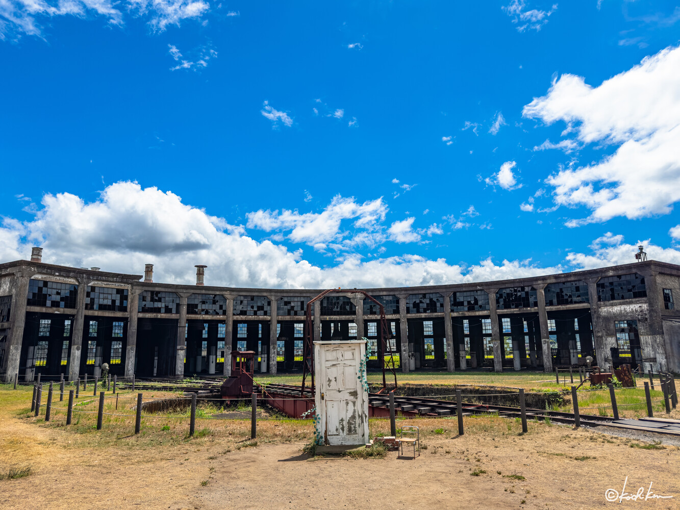 Abandoned modernist institutional building with boarded windows under blue sky