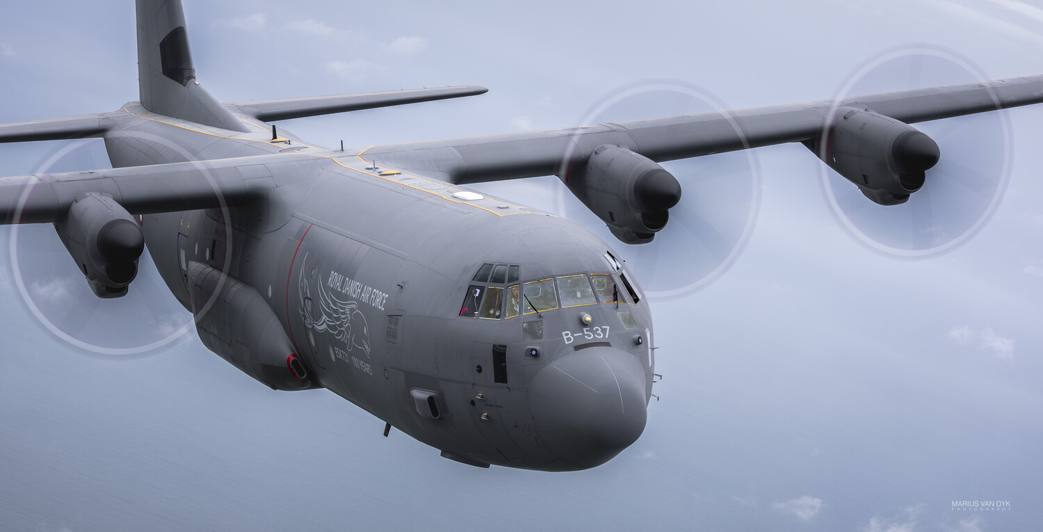 Illustration of a large military transport aircraft in flight with four turboprop engines